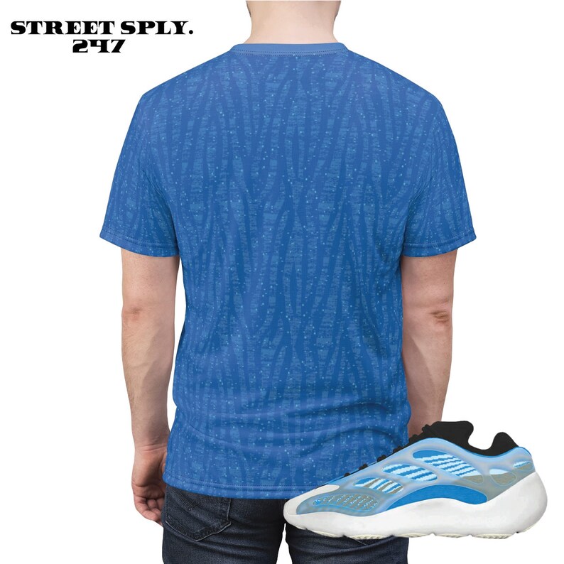 Puede incluir: Una camiseta azul y blanca con estampado y un par de zapatillas azules y blancas. La camiseta tiene un peque&ntilde;o logotipo que dice "STREET SPLY. 247".