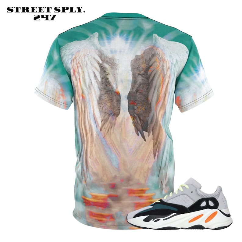 K&ouml;nnte beinhalten: Ein gr&uuml;nes, wei&szlig;es und orangefarbenes Batik-T-Shirt mit einem Motiv von Engelsfl&uuml;geln. Das T-Shirt wird mit einem Paar wei&szlig;er, schwarzer und orangefarbener Sneaker kombiniert.