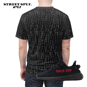 May include: A black t-shirt with a grey zebra print pattern. The t-shirt has a crew neck and short sleeves. A black and red sneaker with the text "SPLY-350" is shown in the image.