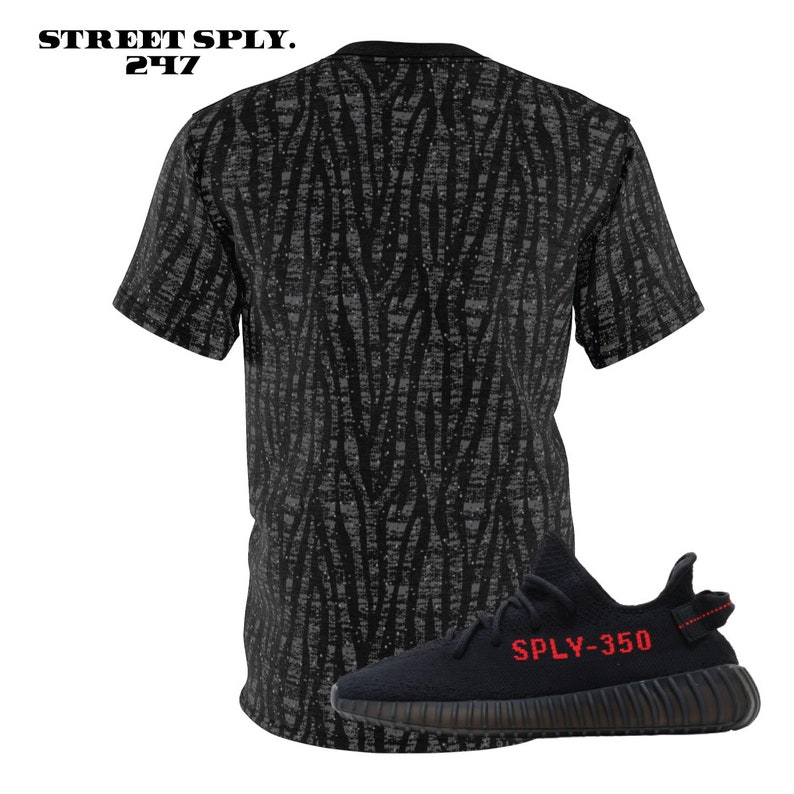 May include: Black and grey patterned t-shirt with a black and red sneaker with the text "SPLY-350" on the side.