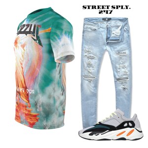 K&ouml;nnte beinhalten: Ein gr&uuml;nes, blaues und oranges T-Shirt mit dem Text "IZZY" und "LOVE YOU". Hellblaue, ausgefranste Jeans und graue, schwarze und orangefarbene Sneaker.