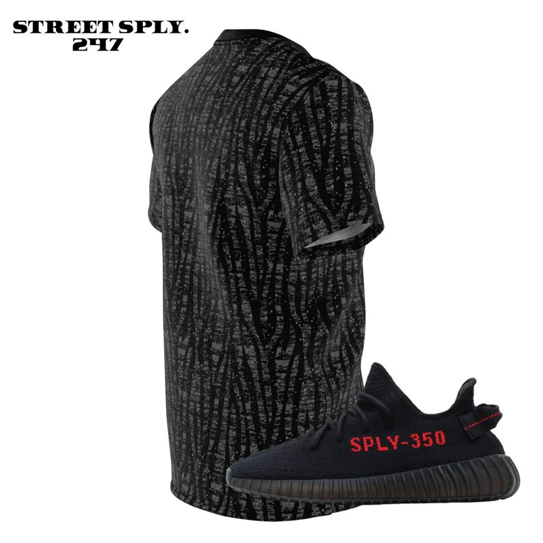 May include: Black and grey patterned t-shirt with black and red sneakers that say "SPLY-350" on the side.