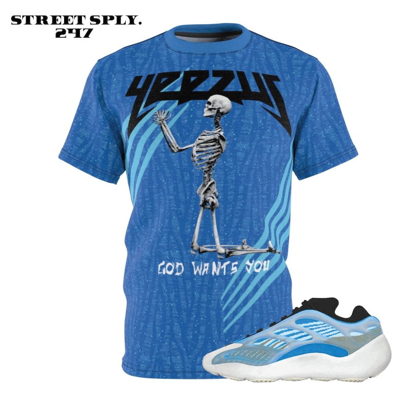 Puede incluir: Una camiseta azul con un gr&aacute;fico de esqueleto y el texto "YEEZUS" y "GOD WANTS YOU". Un par de zapatillas blancas y azules con un acento negro.