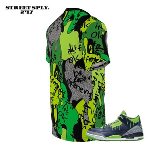 Puede incluir: Una camiseta gr&aacute;fica verde, negra y amarilla con el texto "Street Sply. 24/7" y una zapatilla negra y verde con suela blanca.