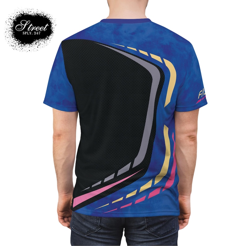 Puede incluir: Una camiseta gr&aacute;fica azul, amarilla, rosa y gris con un dise&ntilde;o geom&eacute;trico. La camiseta tiene un patr&oacute;n de malla negra en la espalda.