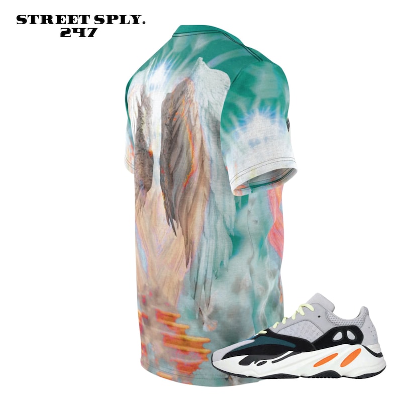 K&ouml;nnte beinhalten: Ein gr&uuml;nes, wei&szlig;es und orangefarbenes Batik-T-Shirt mit einem Motiv von Engelsfl&uuml;geln. Das T-Shirt wird mit einem Paar wei&szlig;er, schwarzer und orangefarbener Sneaker mit einer dicken Sohle kombiniert.