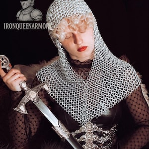 May include: A person wearing a silver chainmail hood and holding a silver sword. The sword has an ornate handle and a cross design. The image includes the text "IRONQUEENARMORY" and a knight's helmet logo.