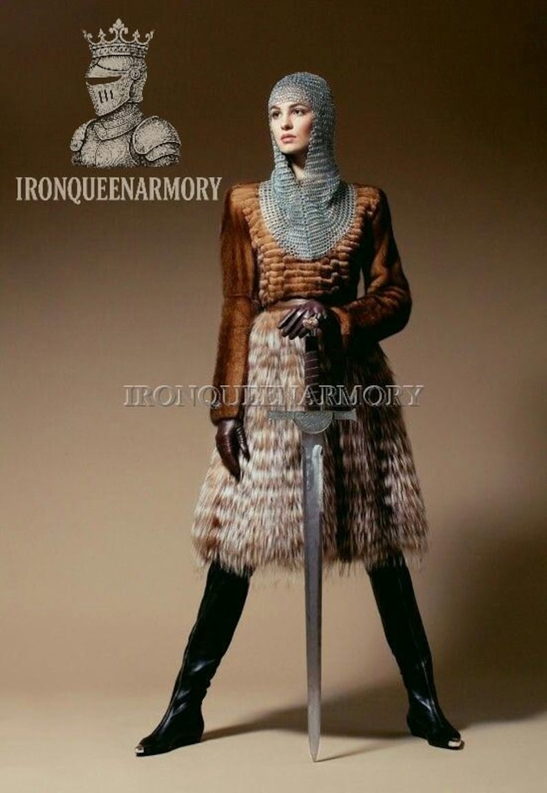May include: A person in a medieval-inspired outfit, holding a sword. They wear a chainmail hood, a brown fur coat, and a fur skirt. The outfit is completed with black leather boots and gloves. The image includes the text "IRONQUEENARMORY".