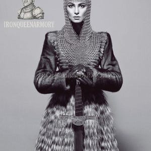 May include: A monochrome image featuring a person in chainmail, a fur coat, and holding a sword. The image includes the text "IRONQUEENARMORY" and a drawing of a knight's helmet.