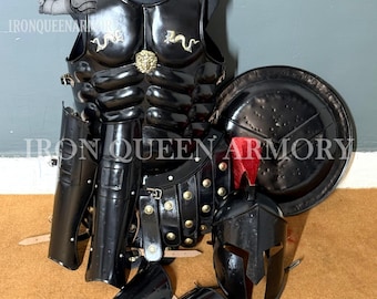 May include: Black armor set including a breastplate, helmet, shield, and arm guards. The breastplate features decorative gold accents and is displayed on a mannequin. The shield has a red accent. The set is designed for historical reenactment or display.