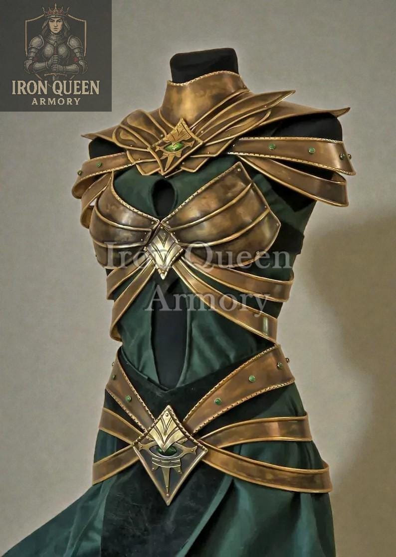 May include: A gold-colored breastplate and shoulder armor set with green accents, displayed on a mannequin. The armor is layered over a dark green fabric. The Iron Queen Armory logo is visible in the upper left corner.