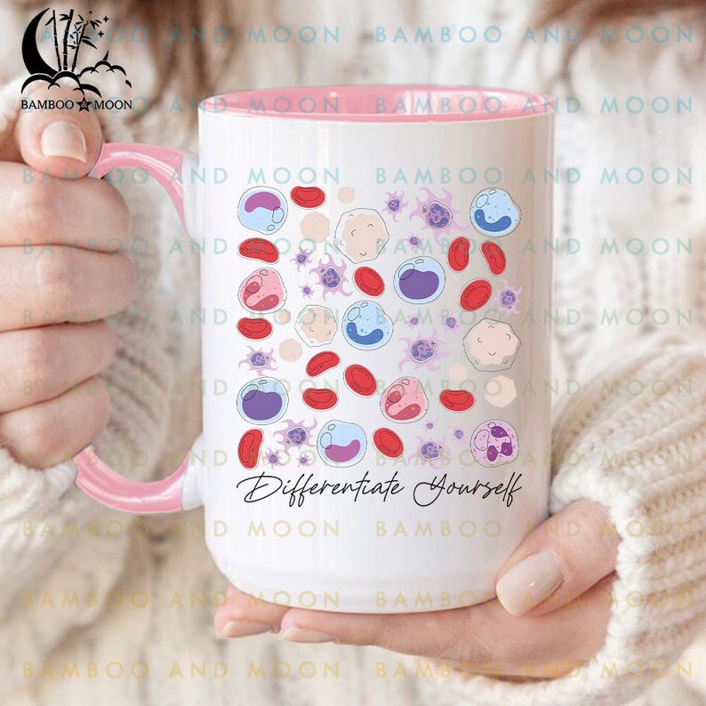 May include: White ceramic mug with a pink interior and handle, featuring a colorful illustration of blood cells. The mug has the text "Differentiate Yourself" in a script font.