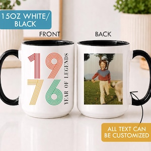 Puede incluir: Dos tazas de cerámica blanca de 15 oz con asas e interiores negros. La taza frontal muestra el texto 1976 YEAR OF LEGENDS en rojo, naranja, amarillo y verde. La taza trasera muestra una fotografía antigua de un niño corriendo en un campo.