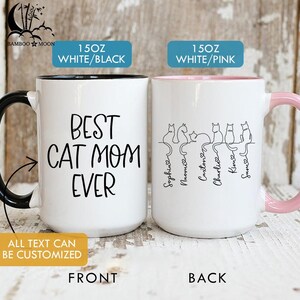 May include: Two white ceramic mugs. One has a black handle and the text "BEST CAT MOM EVER". The other has a pink handle and a line drawing of cats with names. Both mugs are 15 oz.