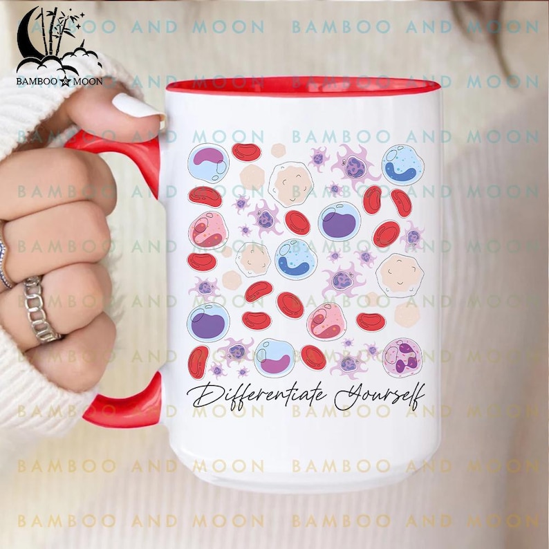 May include: White ceramic mug with a red interior and handle. The mug features a pattern of colorful cell illustrations and the text "Differentiate Yourself" in black script. The mug is held by a person.