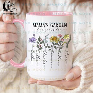 May include: White ceramic mug with a pink handle. The mug has a floral design with the text "Mama's Garden - love grows here" and five names: Mina, Kellie, Kimmie, Charlie, and Sullie.
