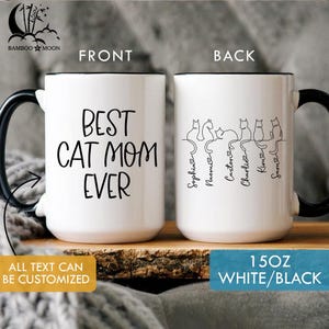 May include: White ceramic mug with black handle and rim. The front reads "BEST CAT MOM EVER" in black script. The back features cat silhouettes with names. The mug is 15 oz.