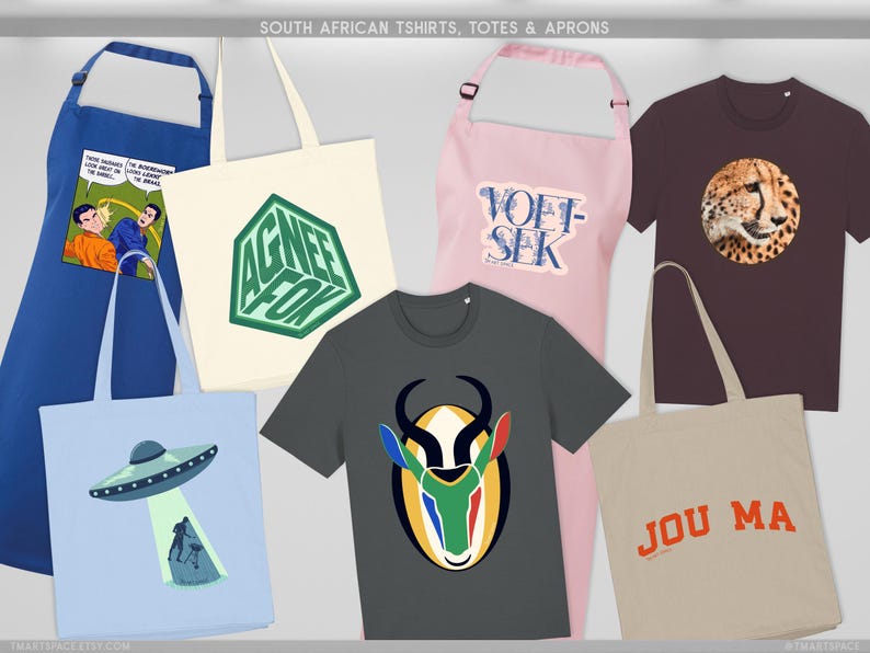 May include: A selection of South African themed t-shirts, totes, and aprons. Features a blue apron with a comic strip, a cream tote bag with a green geometric design, a grey t-shirt with an antelope graphic, and a light blue tote bag with a UFO design.