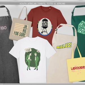May include: A selection of South African themed aprons, tote bags, and t-shirts. The items display text and graphic designs. The aprons are grey, beige, and green. The t-shirts are red and white. The tote bags are beige and yellow.