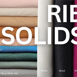 Pode incluir: Uma coleção de amostras de tecido canelado de cor sólida em várias tonalidades. As cores incluem rosa, bege, camelo, ferrugem, pêssego, pavão, verde caçador, sálvia, azul marinho, branco, preto e magenta. A palavra "SOLIDS" é exibida em letras brancas grandes.