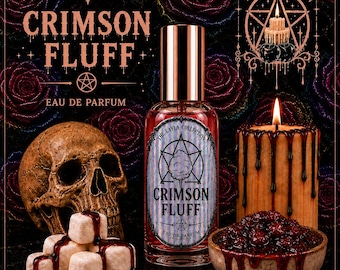 Könnte beinhalten: Eine Glasflasche Crimson Fluff Eau de Parfum mit Metallverschluss und einem Etikett mit Pentagramm- und Zuckerwattemotiv. Die Flasche ist umgeben von einem menschlichen Schädel, weißen Würfeln mit dunklem Sirup und einer brennenden Kerze.