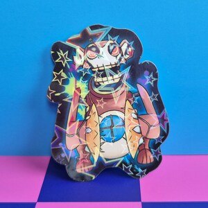 May include: A holographic sticker featuring a cartoon character with a skeletal face and a star-shaped outline. The character has a brown torso and is surrounded by colorful, electric-like effects. The background is a checkered pink and blue pattern.
