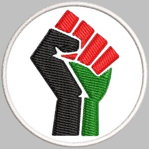 Può includere: Toppa ricamata con un pugno chiuso nero, rosso e verde, simbolo di solidarietà. Il pugno è su sfondo bianco, circondato da un bordo cucito. Adatto per abbigliamento o accessori.