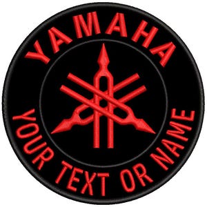 May include: Embroidered patch with the Yamaha logo in red on a black circular background. The text "YAMAHA" is arched across the top, and "YOUR TEXT OR NAME" is arched across the bottom. The Yamaha logo is a stylized design.