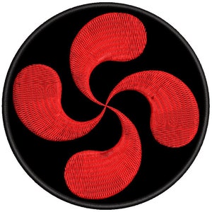 Puede incluir: Un símbolo lauburu rojo sobre un fondo circular negro. El lauburu es un símbolo tradicional vasco.