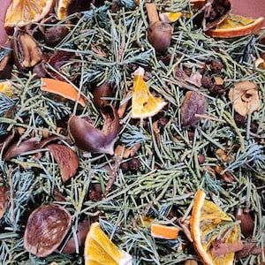 May include: A close-up of a bowl filled with potpourri. The potpourri is a mix of dried orange peels, pine needles, cinnamon sticks, and other natural ingredients. The potpourri is a warm, earthy brown color with hints of orange.