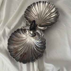 Plat de service vintage en métal argenté, double coquille Saint-Jacques, compartimenté, avec poignée anneau et pieds en forme de dauphin, style Hollywood Regency Coastal
