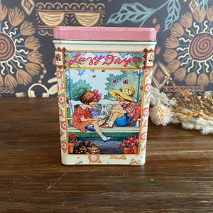 Vintage "Faule Tage" Zinn-Münzbank, illustrierte Kinder Metallbank, Mädchen auf der Verandaschaukel, Junge, der auf der Treppe sitzt und Soda trinkt."