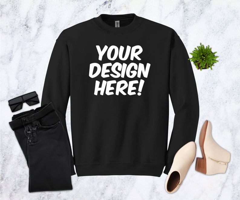 May include: Black sweatshirt with the text "YOUR DESIGN HERE!" in white lettering.