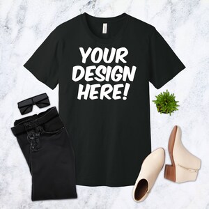 K&ouml;nnte beinhalten: Schwarzes T-Shirt mit wei&szlig;em Text, der "YOUR DESIGN HERE!" lautet.