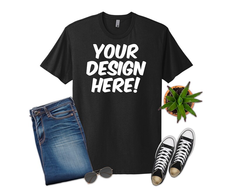 May include: Black t-shirt with the text "YOUR DESIGN HERE!" in white, paired with blue jeans, black and white sneakers, sunglasses, and a small potted succulent. A casual, everyday outfit.