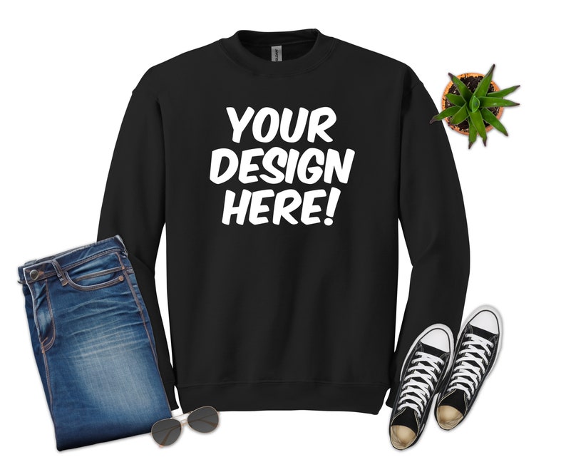 May include: Black sweatshirt with long sleeves and a crew neck. The sweatshirt has the text "YOUR DESIGN HERE!" printed in white on the front.