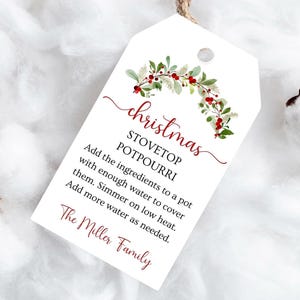 May include: A white tag with a Christmas stovetop potpourri recipe. The tag has a watercolor floral design with red berries and green leaves. The text includes instructions and "The Miller Family".