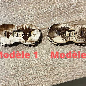 Peut inclure: Deux modèles en bois avec un design de vaisseau spatial et les numéros 615 et 911 dessus. Les modèles sont étiquetés "Modèle 1" et "Modèle 2".