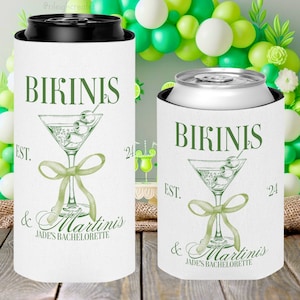 May include: Two white can coolers with green text and a green martini glass design. The text reads "Bikinis & Martinis" and "Jade's Bachelorette" with the year "'24" on the right side of the coolers.