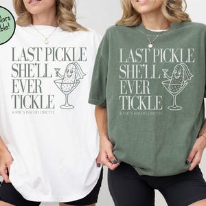 May include: White and moss green t-shirts with the text "LAST PICKLE SHE'LL EVER TICKLE" and a cartoon pickle in a martini glass. The text "KATIE'S BACHELORETTE" is below the main text. More colors are available.