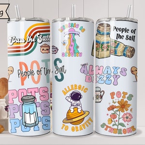 May include: Three stainless steel tumblers with colorful designs. The first tumbler has a rainbow design with the text "Pass the Salt" and "People of the Salt" with a salt shaker and a pot. The second tumbler has a space theme with the text "Allergic to Gravity" and an astronaut. The third tumbler has a floral design with the text "People of the Salt" and "Always Dizzy" with a salt shaker and a pot.
