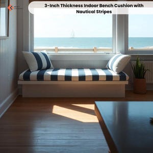 May include: Indoor bench cushion with nautical stripes. The cushion is 3 inches thick and features a blue and white striped pattern. Two matching throw pillows are included. The bench is placed in front of a window overlooking the ocean.