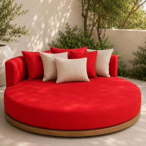 May include: A circular outdoor daybed with a bright red upholstered frame and base. The daybed is arranged with two solid red square pillows, two beige square pillows, and one central beige rectangular pillow with a vertical ribbed texture.