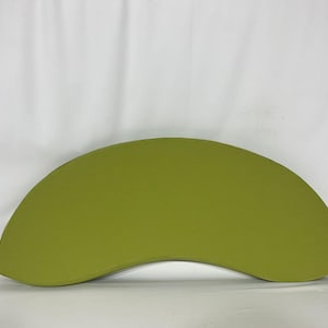 May include: A crescent-shaped, green cushion or pouf. The cushion is made of a soft, textured fabric.