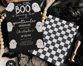 May include: Black invitation card with the text "our little BOO is turning two!" and cute ghost illustrations. A black and white checkered card and a gold skull are also in the image. The invitation is for a birthday party.