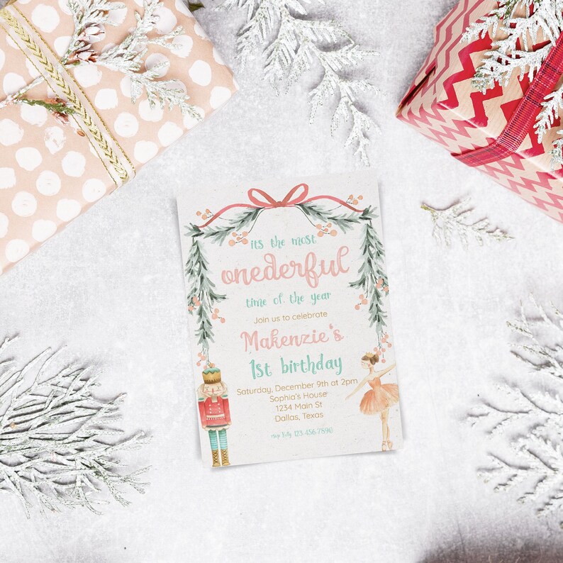 May include: A pink and green Christmas-themed invitation for a 1st birthday party. The invitation features a Nutcracker and a ballerina with a wreath of greenery and red berries. The text reads "It's the most wonderful time of the year. Join us to celebrate Makenzie's 1st birthday. Saturday, December 9th at 2pm. Sophia's House, 1234 Main St, Dallas, Texas.  Reply by 03-456-7590."
