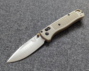 Réplica (copia) del cuchillo Benchmade Bugout 535, cachas de color verde oliva claro, hoja de metal.