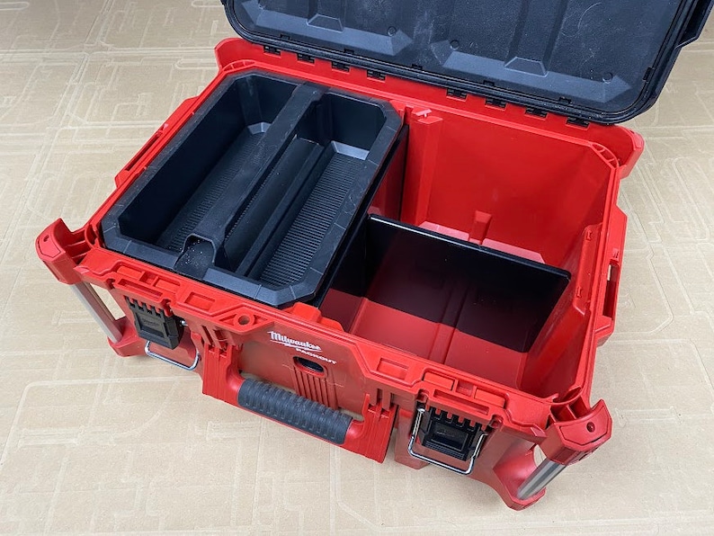May include: An open red Milwaukee Packout tool box with a black interior. The box has a removable divider and a large compartment.