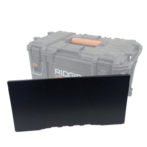 May include: Black plastic storage tray with a textured surface. The tray is designed to fit inside a Ridgid tool box.