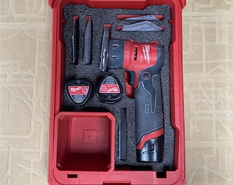 May include: A red Milwaukee M12 FUEL installation drill kit in a red case. The kit includes a drill, batteries, and various accessories, all neatly organized within a foam insert. The case has a clear top.